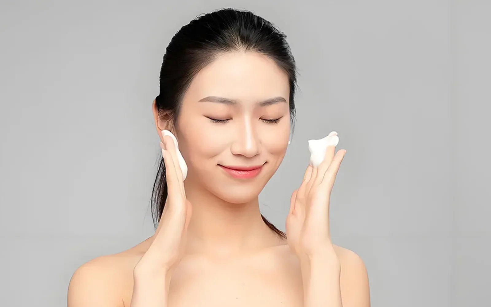 Người phụ nữ rửa mặt nhẹ nhàng với bọt làm sạch